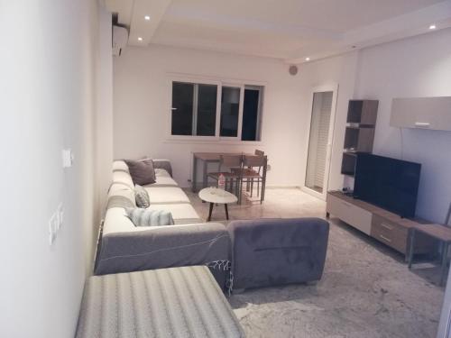 a living room with a couch and a television at Costa Marina 212 in Hammamet