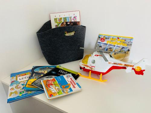 a table with a toy helicopter and some books at Ferienhaus Alte Kaserne in Andernach