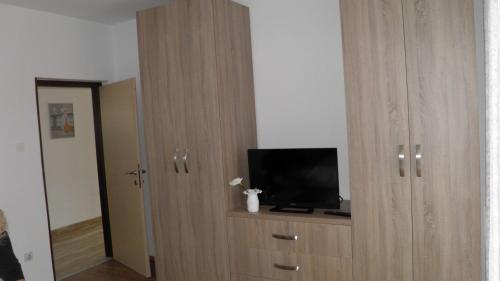 a wooden cabinet with a television on top of it at Apartmani s dvije spavaće sobe 4 osobe in Selce