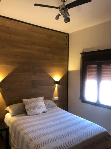 a bedroom with a large bed with a wooden headboard at La Capital del Jerte in Plasencia
