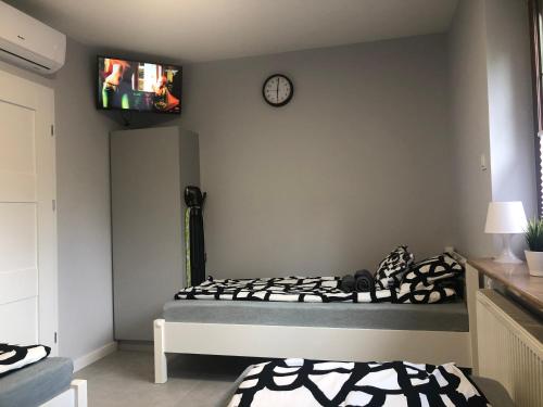 1 dormitorio con 1 cama y TV en la pared en Klimatyzowane Apartamenty i Pokoje przy Targach Kielce, en Kielce