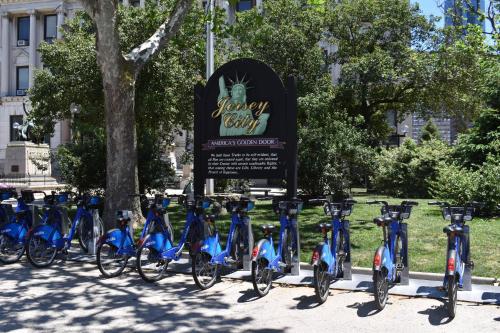 a row of blue bikes parked next to a sign at Riverhouse Extended Stay Apartment in Jersey City