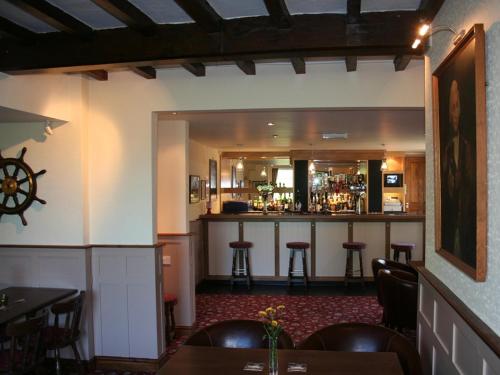 um restaurante com um bar e algumas mesas e cadeiras em The Lord Nelson Inn em Newark upon Trent