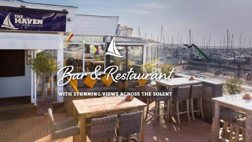a restaurant with sounding ways respects the yacht with tables and chairs at Hoitak in Lymington