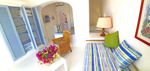 a room with a couch and a table with flowers at Villa Ravino Secret Retreat in Ischia