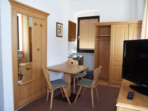 a room with a table and chairs and a television at Hotel Kärntnerhof in Mallnitz