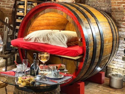 a bed in a wine barrel with a table at Al Silter in Capriate San Gervasio