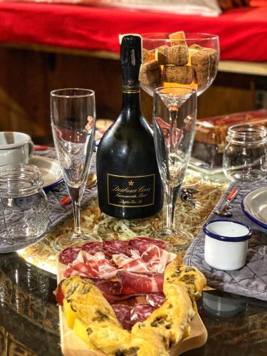 a table with a bottle of wine and wine glasses at Al Silter in Capriate San Gervasio