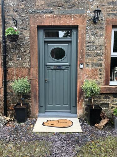 una puerta con un perro pintado delante de una casa en Fox Cottage en Moffat