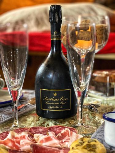 a bottle of wine sitting next to two wine glasses at Al Silter in Capriate San Gervasio