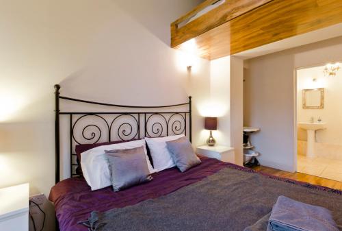 - une chambre avec un grand lit et des oreillers dans l'établissement Egham House Serviced Accommodation 5 Bedrooms 3 Bathrooms entire home, WiFi 1 Gbps, work desks, office chairs, TV 55" Roku, free parking, ONLY Company Stays welcome NO Leisure Stays, sleeps 6 in own beds, à Staines