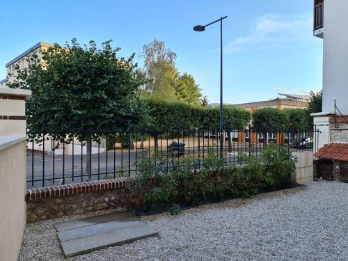 a black fence with a tree and a street light at Atelier Voyageur in Chartres