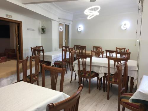 a dining room with white tables and wooden chairs at Hostal La Mexicana in Santander