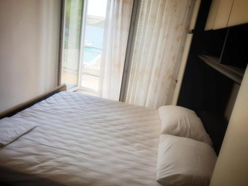 a bed in a room with a window at BetaNovalja in Novalja