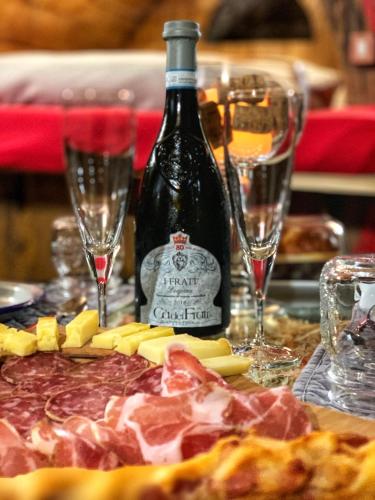 a bottle of wine sitting next to a pizza and glasses at Al Silter in Capriate San Gervasio