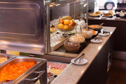 a buffet line with a bunch of food on at Kennedy Slim Hotel in São José