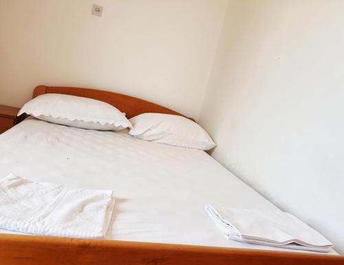a bed with white sheets and two pillows at BetaNovalja in Novalja