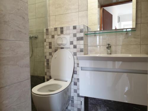 a bathroom with a white toilet and a sink at BetaNovalja in Novalja