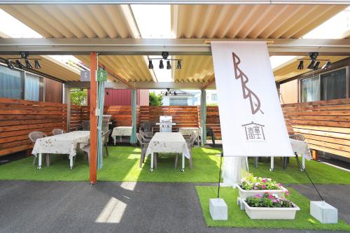 a patio with white tables and chairs and a flag at Villas Fujiyoshida in Fujiyoshida