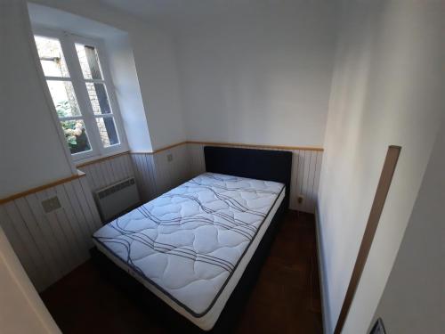 - un petit lit dans une petite chambre avec fenêtre dans l'établissement Appartement Port de St Goustan, à Auray