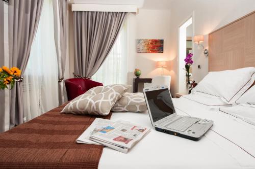 un ordinateur portable assis au-dessus d'un lit dans l'établissement Villa Maria Cristina, à Caserte