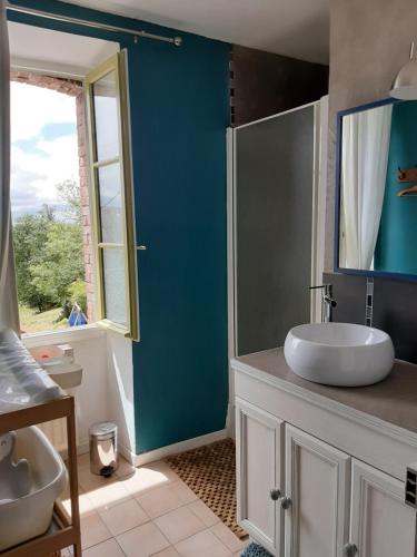 een badkamer met een wastafel en een glazen douche bij La Parenthèse in Folles