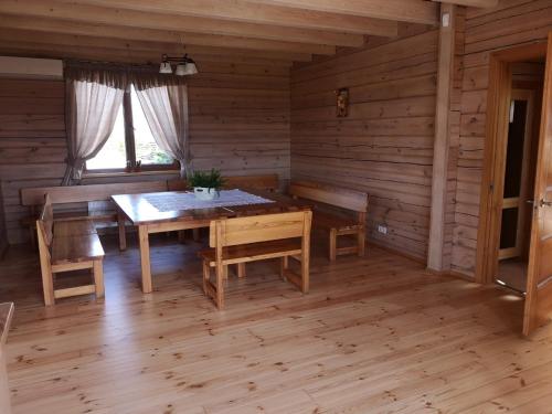 ein Esszimmer mit einem Tisch und Stühlen in einer Hütte in der Unterkunft Abromiškių Sodyba in Elektrėnai