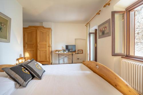 a bedroom with a bed with a wooden headboard at B&B S. Trinità 18 Suites & Rooms in Trento