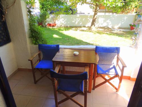 a table and chairs on a patio with a yard at Kalamitsi Studios in Kalamitsi