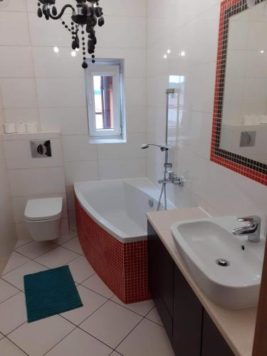 a bathroom with a tub and a toilet and a sink at Apartament na Rynku in Chęciny