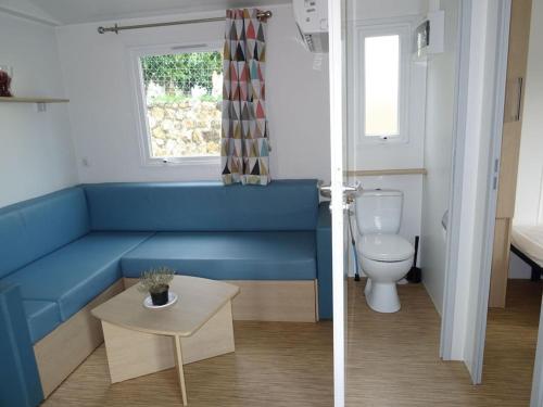 baño con banco azul y aseo en Càmping Vila Village en Sant Feliu de Buixalleu