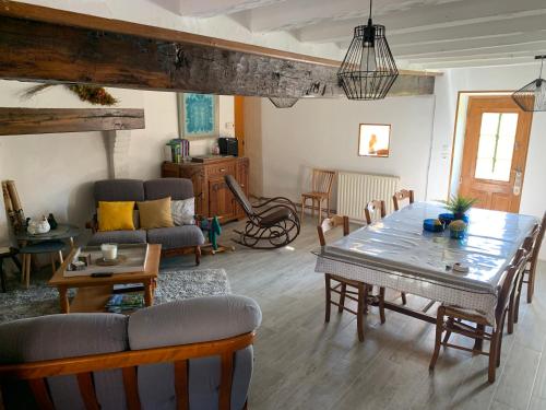 een woonkamer met een tafel en een bank bij La Parenthèse in Folles