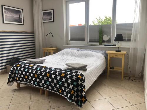 Un dormitorio con una cama con una manta. en Apartament Nordic en Trzęsacz