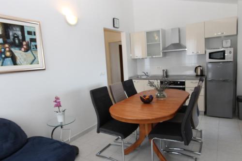 a kitchen with a wooden table and black chairs at Apartments Mareblu in Rabac