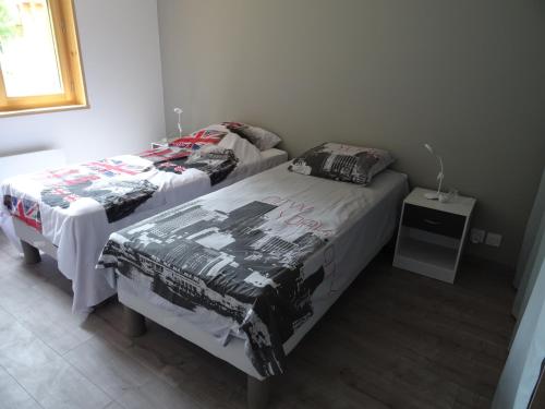 a bedroom with two beds and a table at Chalet neuf 6 personnes in Mont-Saxonnex
