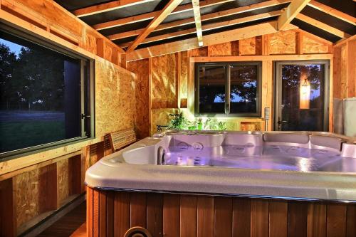 bañera grande en una habitación con ventanas en La Longère de La Chevallerais, en La Chevallerais