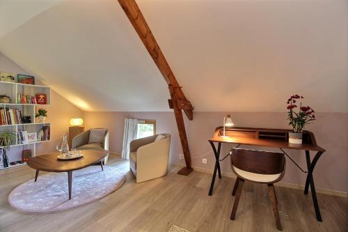 un salon avec un bureau et une table dans l'établissement La Longère de La Chevallerais, à La Chevallerais
