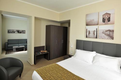 une chambre d'hôtel avec un lit et une chaise dans l'établissement CHC Business Residence, à Gênes