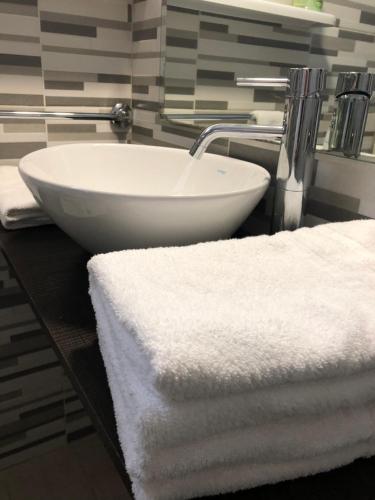 un bagno con lavandino bianco e asciugamani su un bancone di Hotel Margherita a Rimini