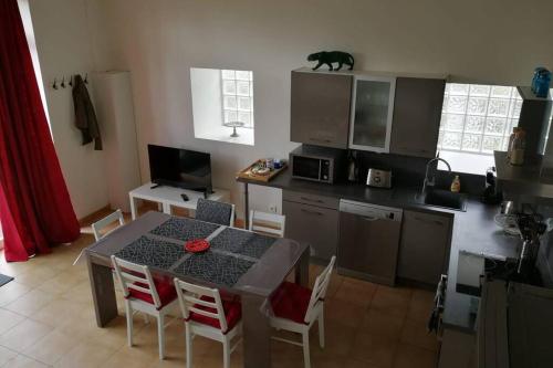 une cuisine avec une table et des chaises et une cuisine avec un chat au-dessus dans l'établissement Les écuries du chateau, à Commes