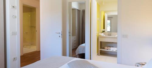 a bedroom with a white bed and a bathroom at DIEHOLIDAYBUCHT in Biograd na Moru