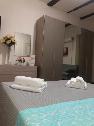 two towels sitting on a bed in front of a mirror at MACALELU HOUSE in Vietri sul Mare