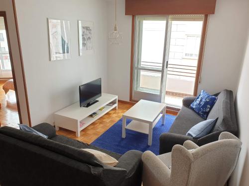 a living room with two couches and a tv at Céntrico, amplio y bonito apartamento en Cambados in Cambados