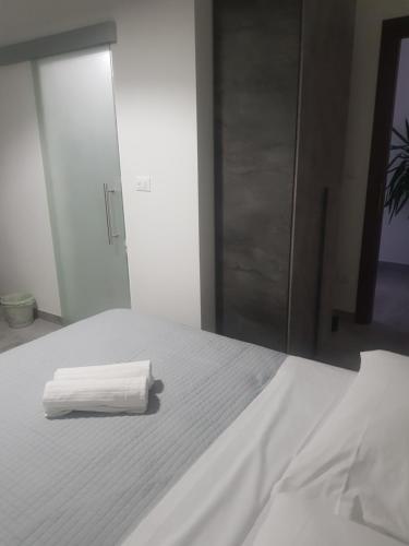 a white bed with a stack of towels on it at B&B FRONTEMARE San Salvo Marina CH in San Salvo