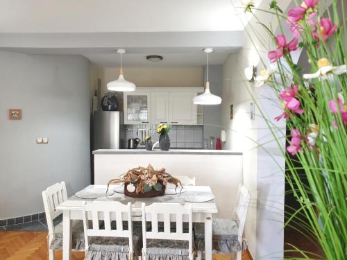cocina y comedor con mesa blanca y sillas en Apartments Kim, en Novalja