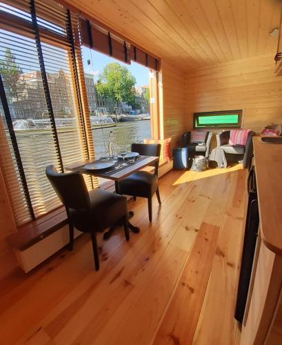 a dining room with a table and chairs in a room at Mar&Mar Houseboat Studio in Amsterdam