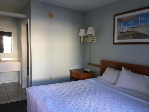 里霍伯斯灘的住宿－High Seas Motel，卧室配有白色的床和窗户。