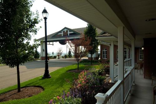 a porch of a house with a lamp post and flowers at Carlisle Inn in Sugarcreek