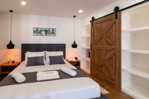 a bedroom with a large bed and a wooden door at Botun Luxury Apartment in Šibenik