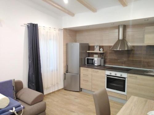 a kitchen with a stainless steel refrigerator and a microwave at APARTMANI MOROVI DVORI in Drage
